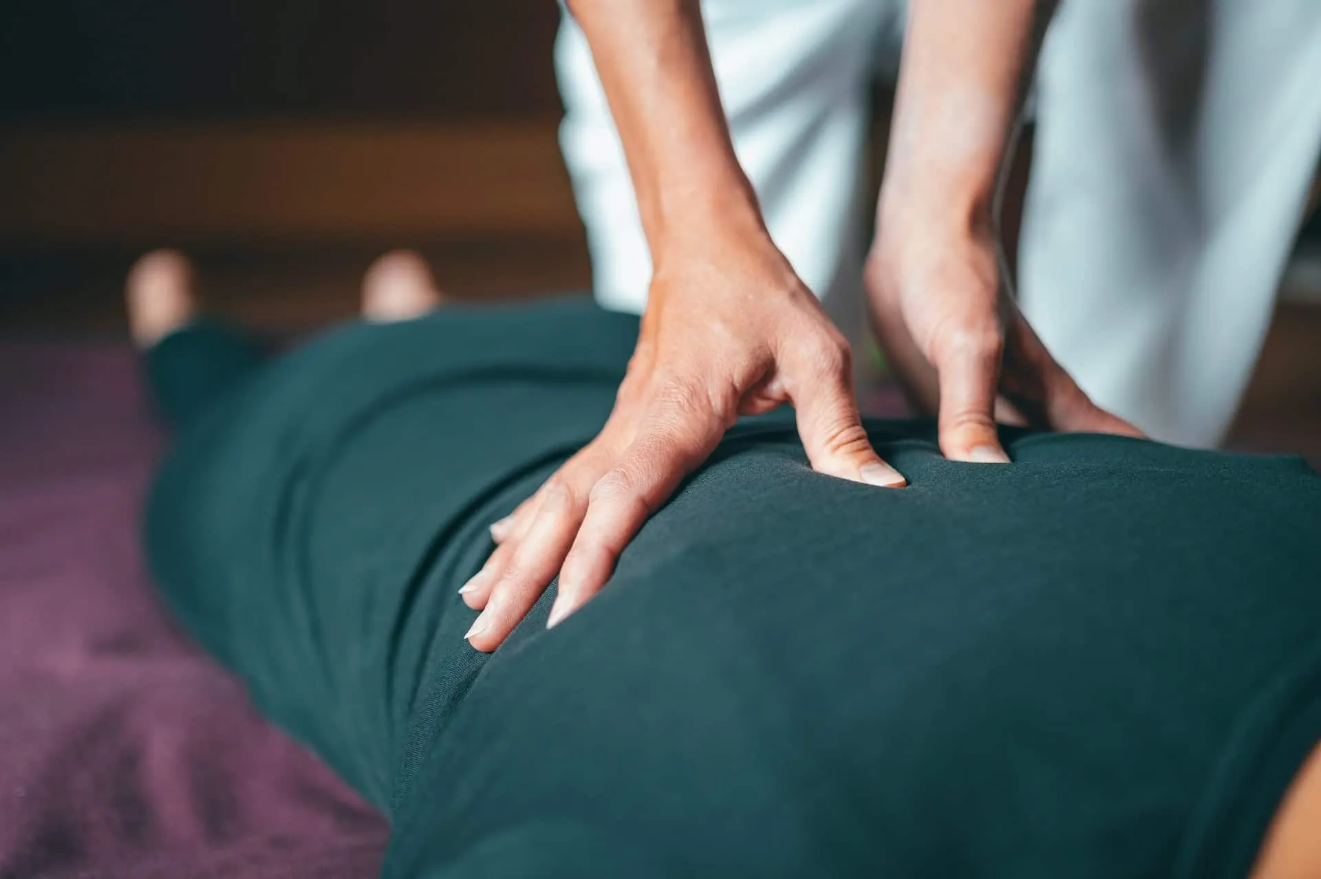 A person receives a back massage with gentle pressure applied.