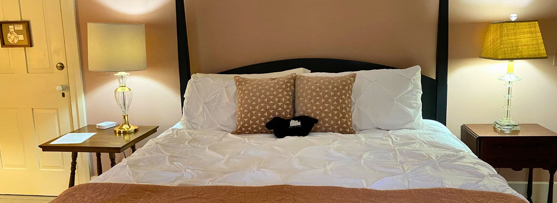 Cozy bedroom with a neatly made bed, decorative pillows, and two bedside lamps.