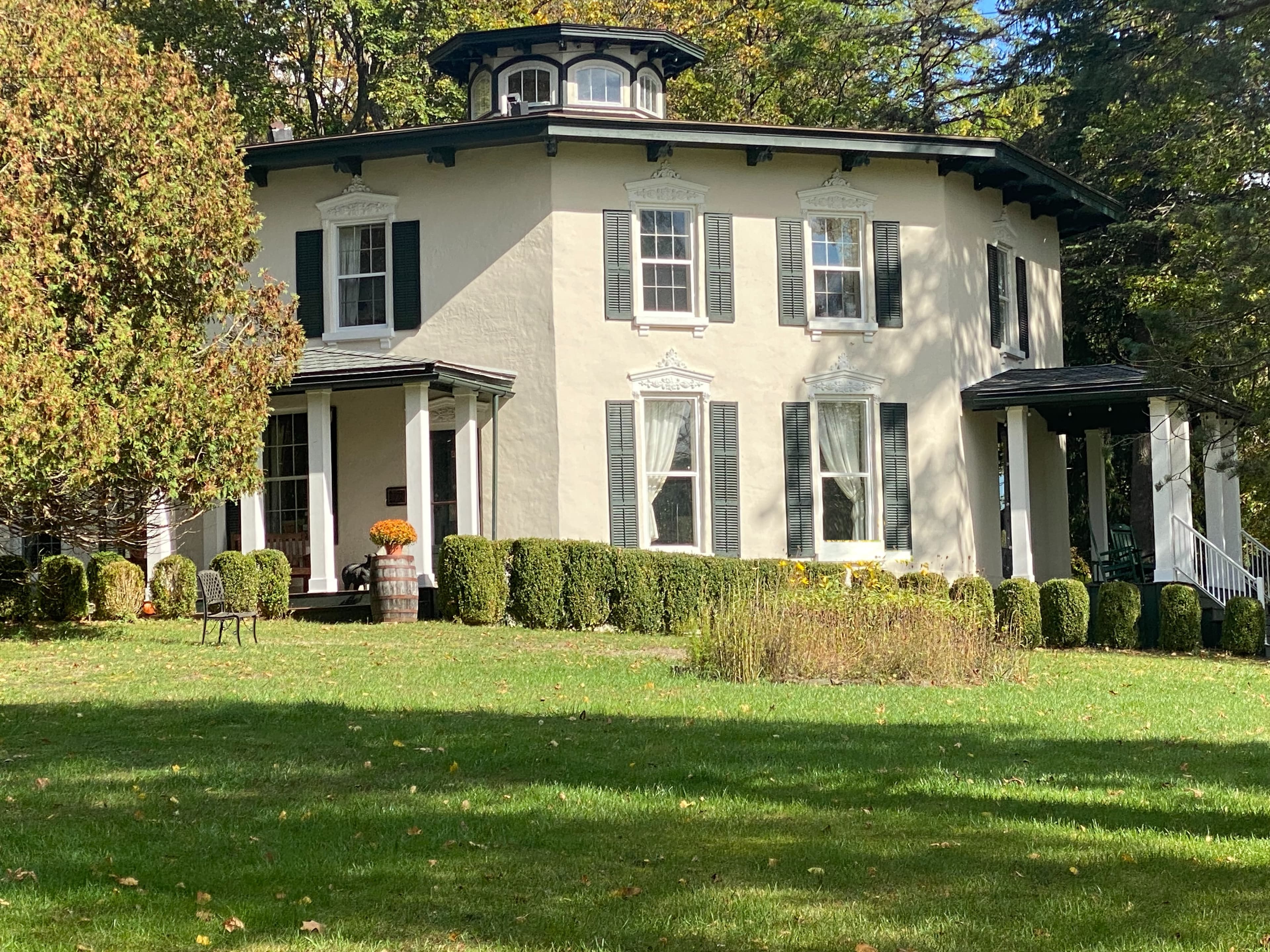 Front facade of a unique octagon home with expansive lawn and surrounded by trees Front facade of a unique octagon home with expansive lawn and surrounded by trees